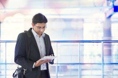 Tren istasyonunda Tablet bilgisayar kullanan adam