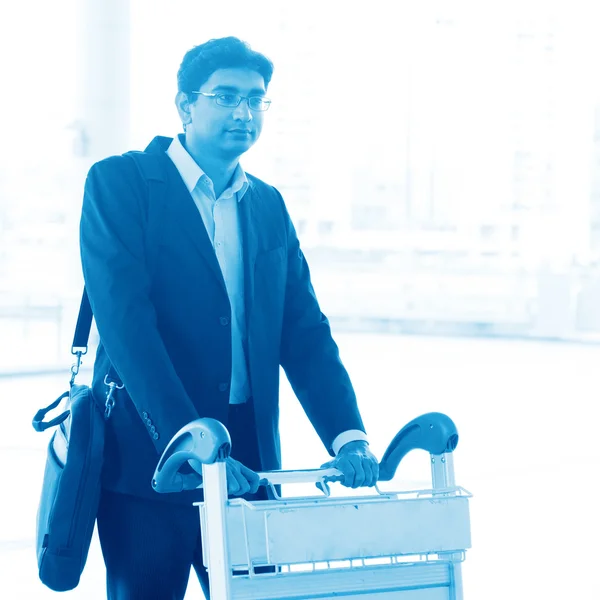 Hombre caminando con carro del aeropuerto — Foto de Stock