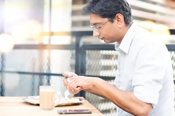 Een man eten voedsel in cafetaria. — Stockfoto