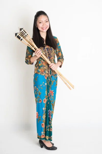 Menina asiática em batik vestido mãos segurando tocha de bambu — Fotografia de Stock