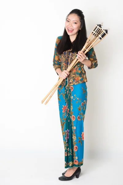 Menina asiática em batik vestido mãos segurando tocha de bambu — Fotografia de Stock