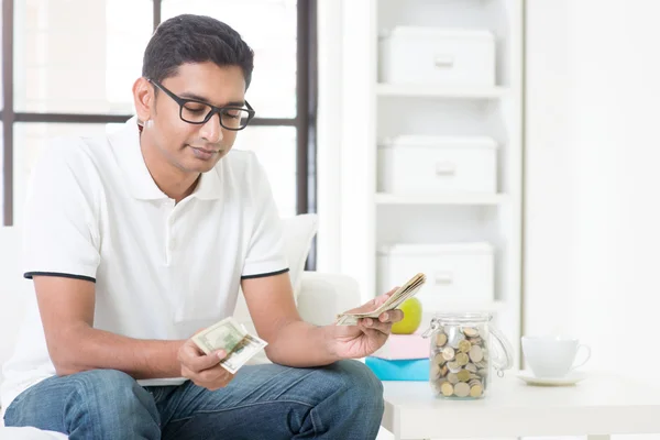 Trauriger indischer Typ, der Geld zählt — Stockfoto