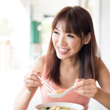 Asian girl eating dumpling noodles