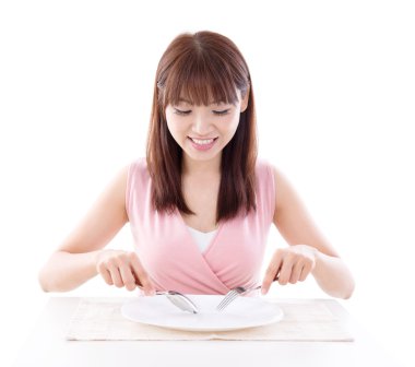 Asian girl eating with fork and spoon