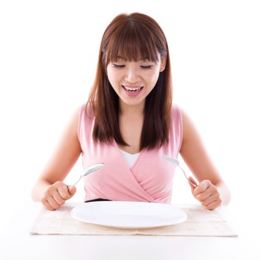Asian girl holding fork and spoon