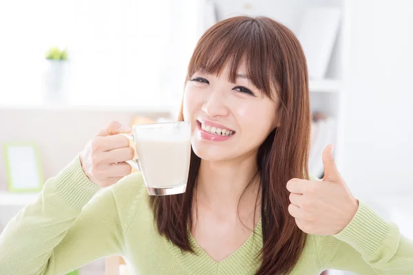 Asian female drinking milk and thumb up — Zdjęcie stockowe