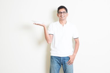 Indian waiter holding an empty plate