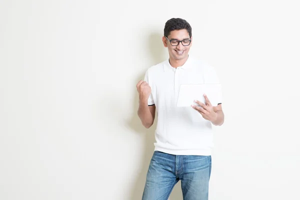 Indian guy using tablet pc and celebrate success — Stockfoto