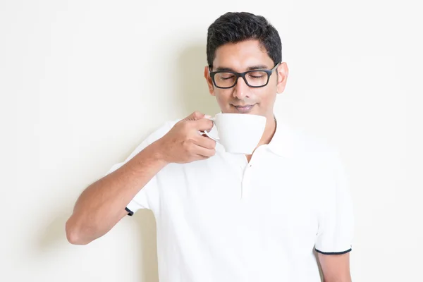 Indian guy holding a cup, drinking and enjoying it — Stock Photo, Image