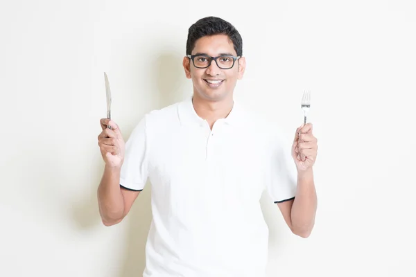 Indian guy holding cutlery fork and knife — Zdjęcie stockowe