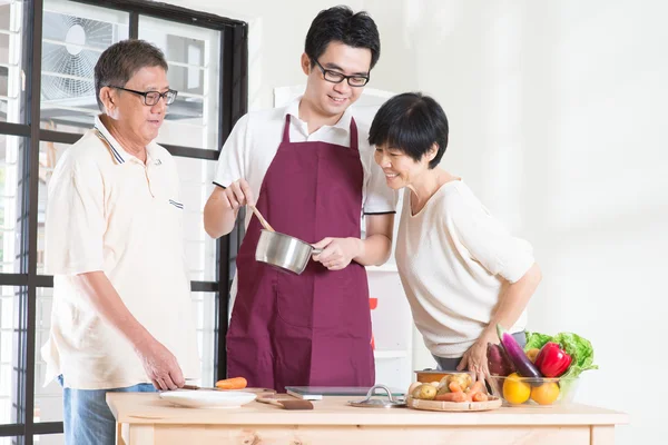 Asian adult son preparing meal — ストック写真