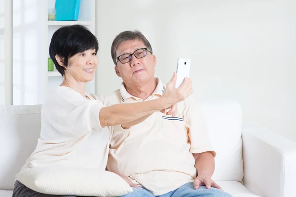 Senior using smart phone making selfie — 图库照片