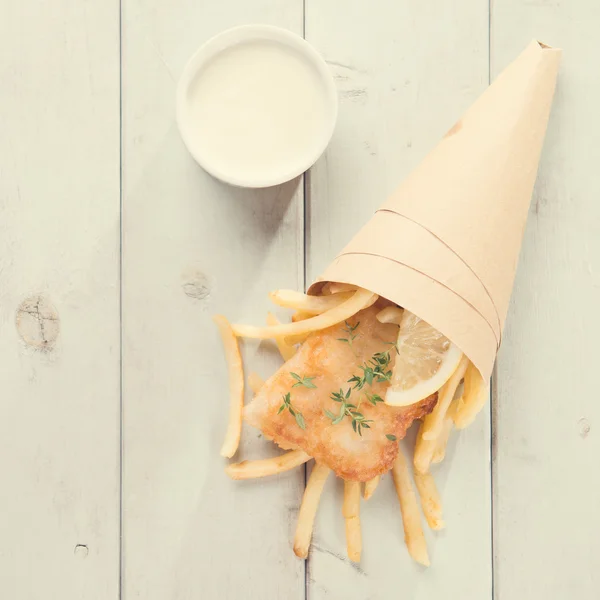 Top vista peixe e batatas fritas em cone de papel, estilo vintage — Fotografia de Stock