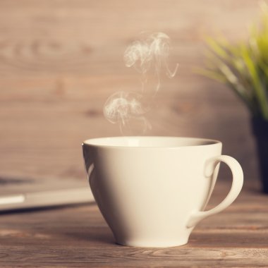 Hot coffee on wooden work desk 