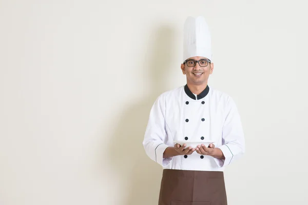 Handsome Indian male chef in uniform holding a plate — Zdjęcie stockowe