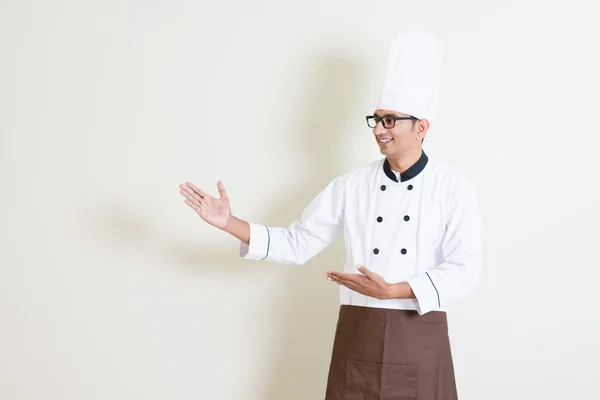 Handsome Indian male chef in uniform showing something — Zdjęcie stockowe