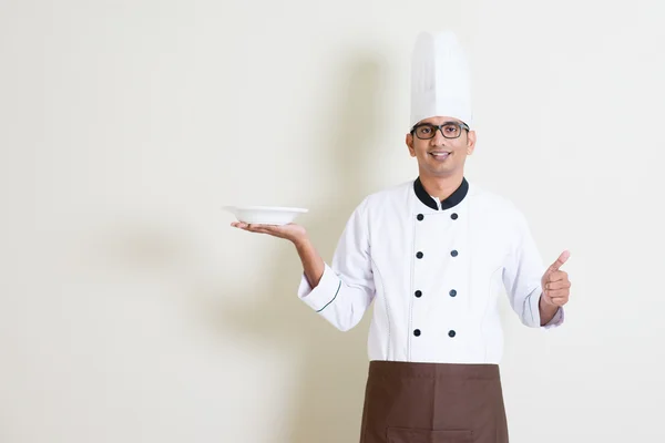 Bonito indiano chef masculino em uniforme segurando uma placa e polegar u — Fotografia de Stock