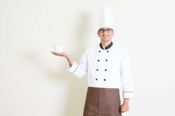 Indian male chef in uniform presenting a coffee cup — стокове фото