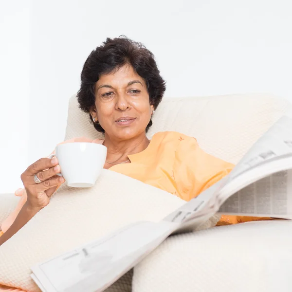 Indian mature mother reading newspaper — Stock fotografie