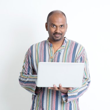 Mature casual Indian man using laptop