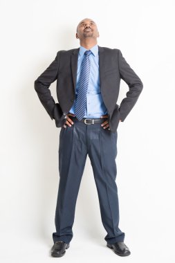 Full length mature Indian businessman looking up
