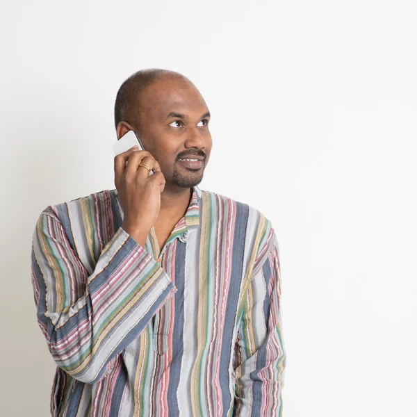 Mature casual Indian man talking on smartphone — Stock Photo, Image