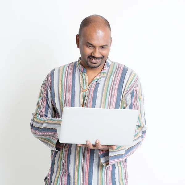 Mature casual Indian man using laptop computer — Stock Photo, Image