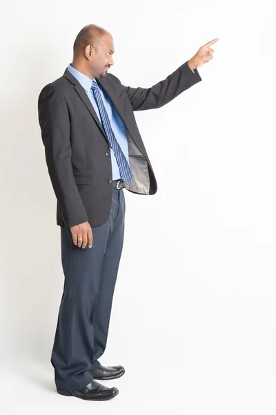 Vista laterale maturo uomo d'affari indiano che punta — Foto Stock