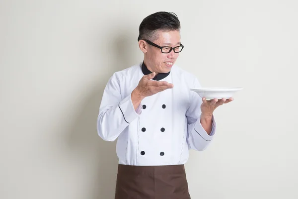 Volwassen Aziatische Chinese chef-kok aanwezig schotel — Stockfoto