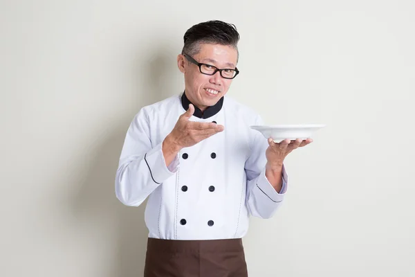 Chef chino asiático maduro presentando plato — Foto de Stock