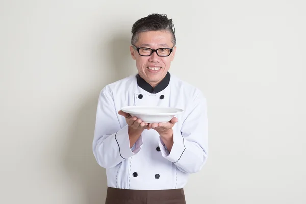 Chef chino maduro presentando plato — Foto de Stock