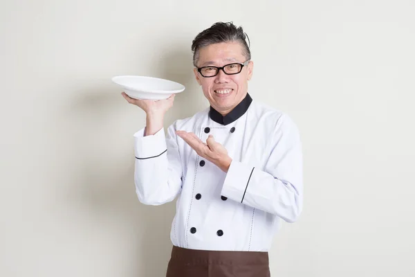 Volwassen Aziatische chef-kok voorstellende schotel — Stockfoto