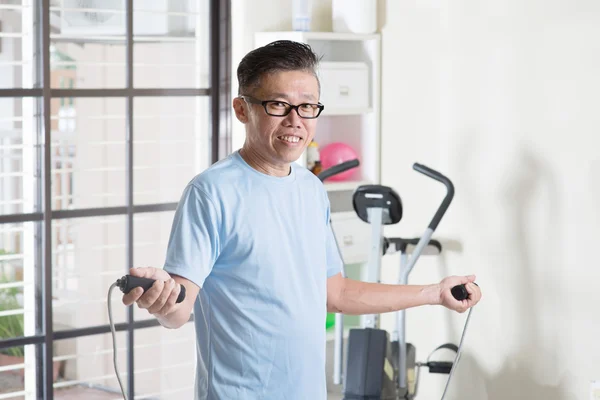 Mature Asian man doing rope skipping exercise — Stock Photo, Image