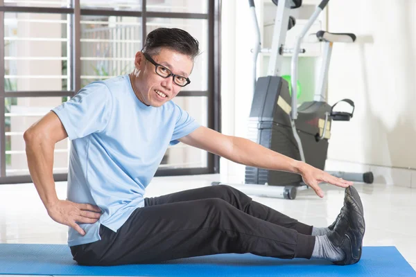 Mature Asian man exercising at gym — Stock Photo, Image