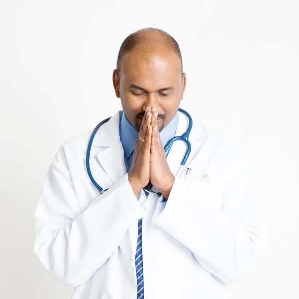 Mature Indian doctor praying — Zdjęcie stockowe