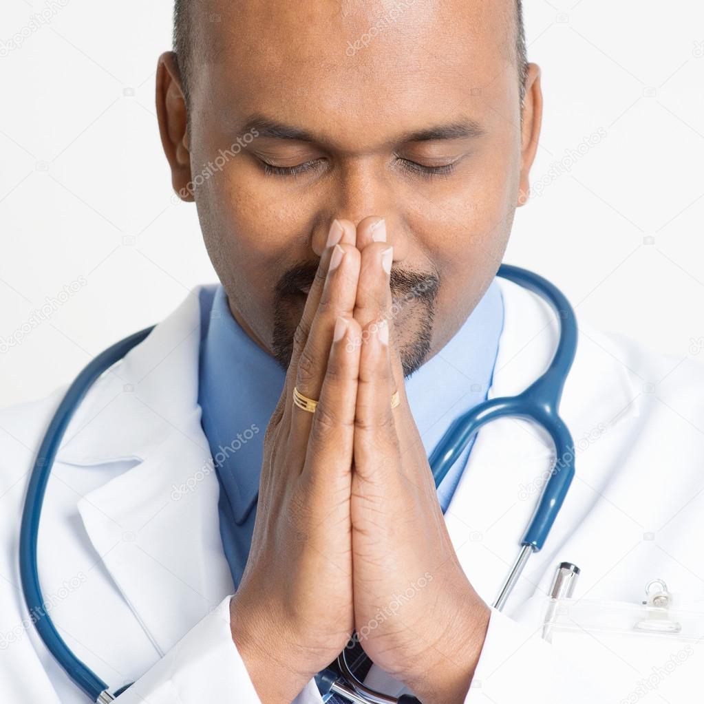 Close up Mature Indian doctor praying Stock Photo by ©szefei 87652098