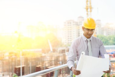 Asian Indian male site contractor engineer inspecting at site