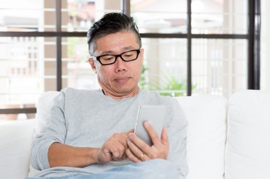 Mature Asian man using smartphone