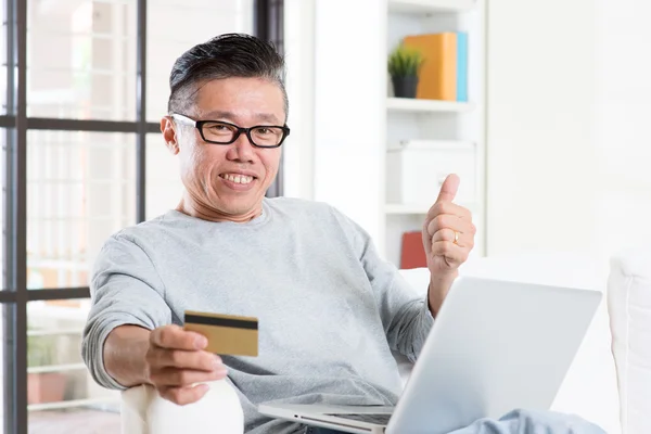 Asian man making online payment and thumb up — Stok fotoğraf