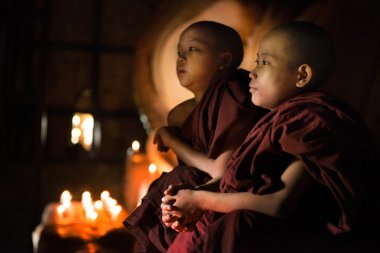 Buddhist novices praying inside temple clipart