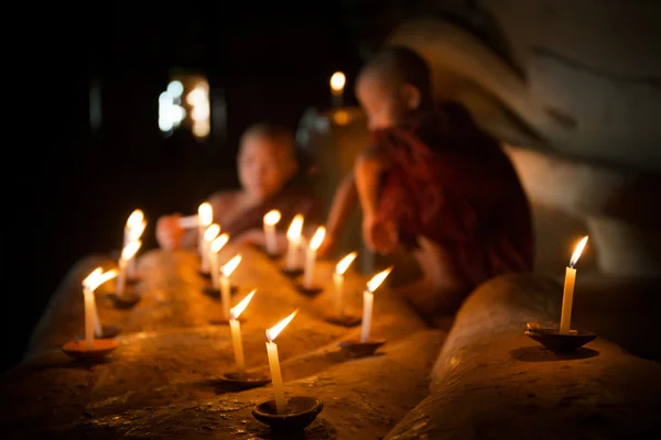 Noviços budistas com luz de vela dentro do templo — Fotografia de Stock