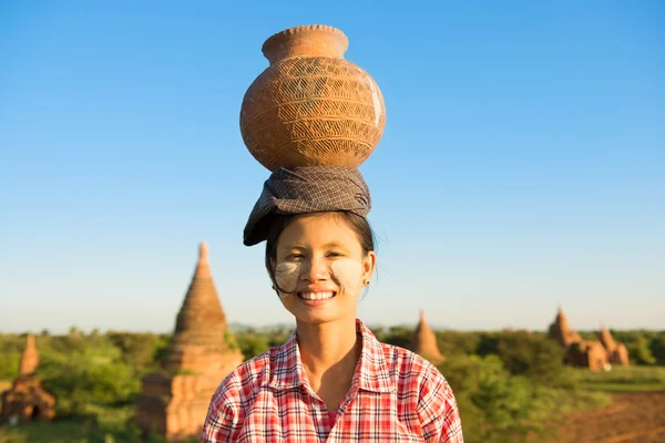 Unga asiatiska traditionella kvinnliga jordbrukare transporterar lerkruka på huvud — Stockfoto