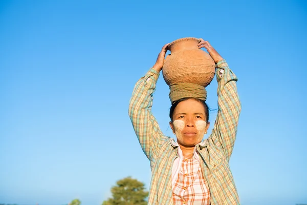 Maturo asiatico tradizionale femmina agricoltore portando argilla pot su testa — Foto Stock