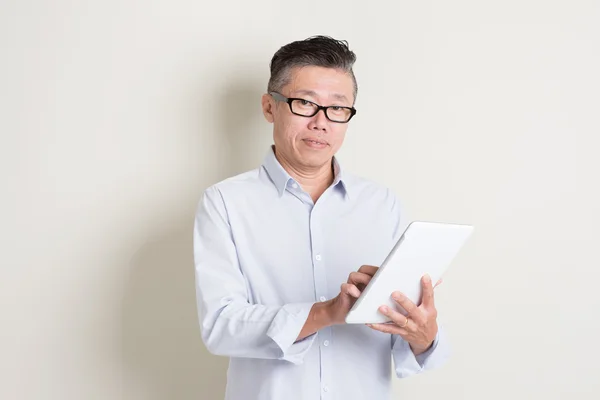 Portrait of mature Asian man using tablet computer — Stock Photo, Image