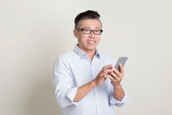 Porträt eines reifen asiatischen Mannes mit Smartphone — Stockfoto