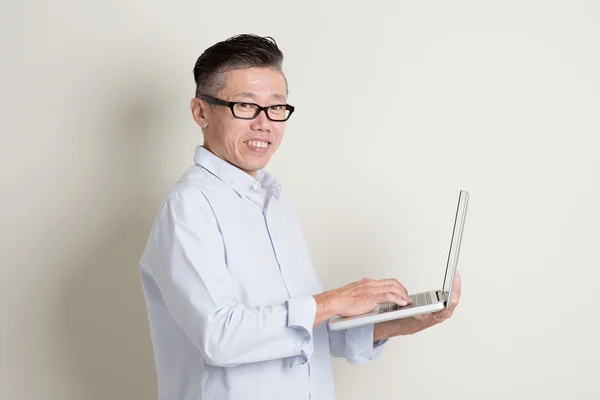 Maturo asiatico uomo utilizzando pc notebook — Foto Stock