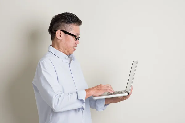 Ältere asiatische Mann mit Computer-Notebook — Stockfoto