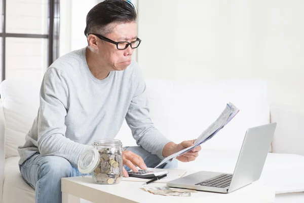 Worried mature Asian man looking at the bills. — 图库照片