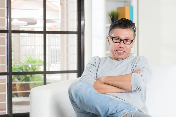 Mature 50s Asian male sitting at home. — Stockfoto