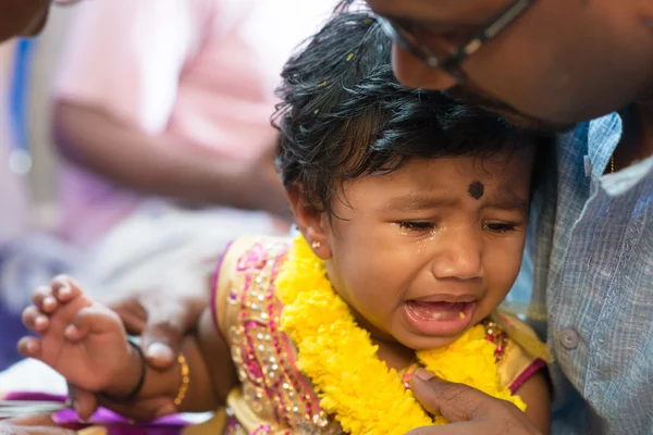 Dziecko dziewczynka płacze w ceremonii przekłuwania uszu — Zdjęcie stockowe